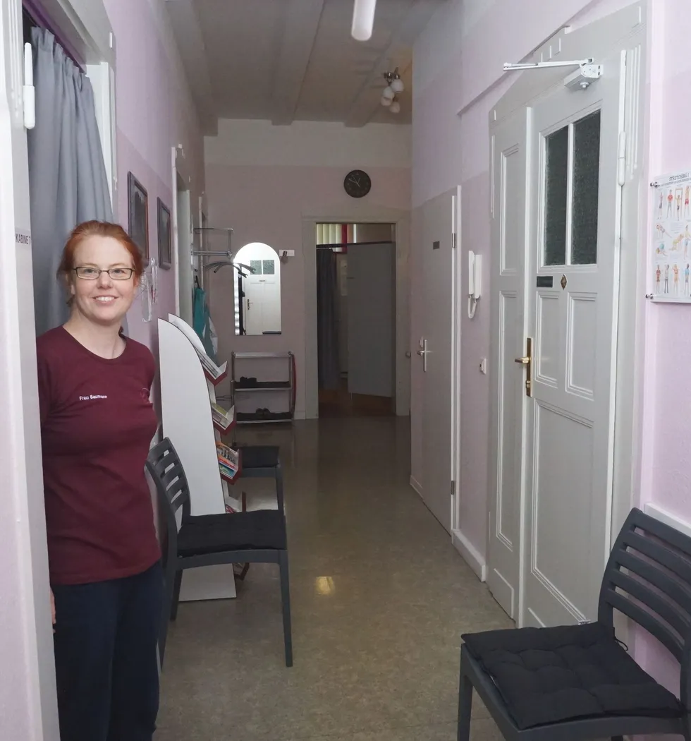 Praxisflur mit Sitzgelegenheiten und Frau Baumann